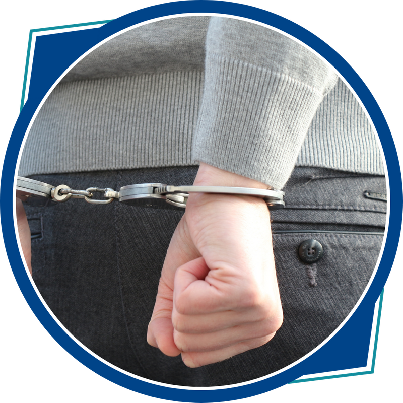 hands in handcuffs behind back, nice sweater and dress pants