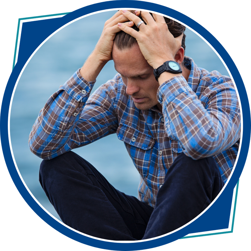 distressed man sitting with head in hands, elbows on knees